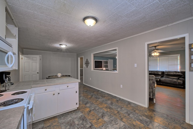 kitchen with stone finish flooring, white appliances, white cabinets, tile counters, and ceiling fan