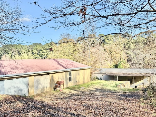 230 Dogwood Ests, Hemphill, TX 75948 - back of property featuring an outbuilding, a wooded view, metal roof, and a pole building