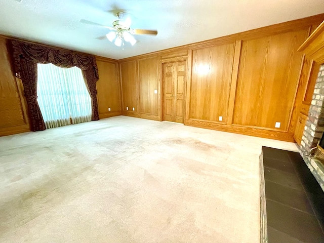 carpeted spare room with ceiling fan and wooden walls