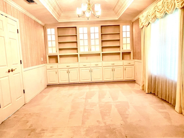 interior space featuring a tray ceiling, a notable chandelier, and crown molding