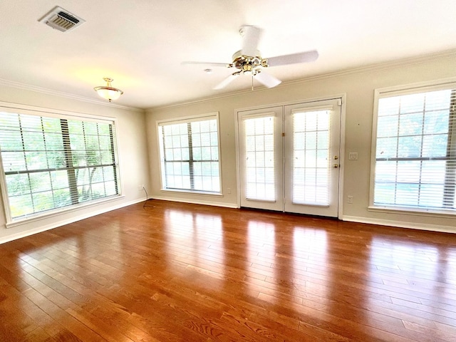 empty room with ornamental molding, wood-type flooring, and ceiling fan