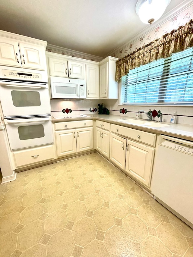 kitchen with sink, white cabinetry, tasteful backsplash, ornamental molding, and white appliances