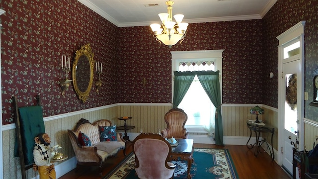 110 Market St, Hemphill, TX 75948 - living area with a notable chandelier, wallpapered walls, wood finished floors, crown molding, and wainscoting