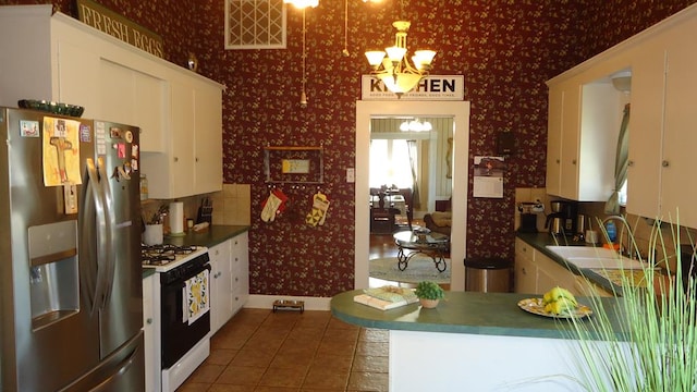 110 Market St, Hemphill, TX 75948 - kitchen featuring visible vents, wallpapered walls, range with gas stovetop, stainless steel fridge, and a sink