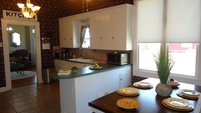110 Market St, Hemphill, TX 75948 - kitchen featuring stainless steel microwave, white cabinets, a wealth of natural light, and a sink