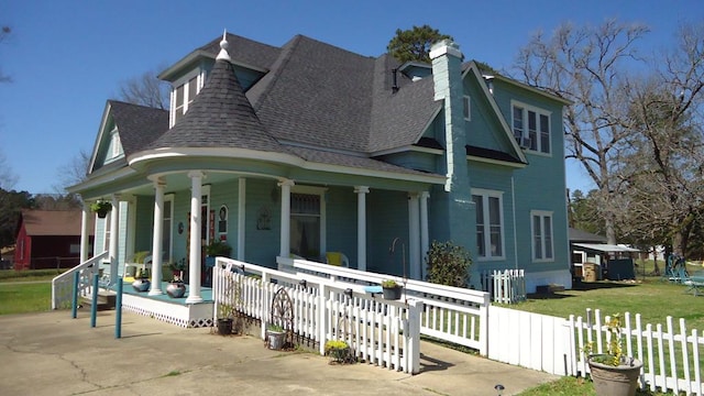 110 Market St, Hemphill, TX 75948 - view of front of property featuring a chimney, covered porch, a shingled roof, and fence