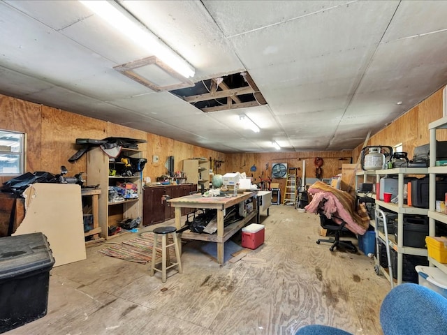 basement featuring a workshop area and wooden walls