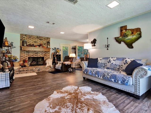 living room with dark hardwood / wood-style flooring, a textured ceiling, and a brick fireplace