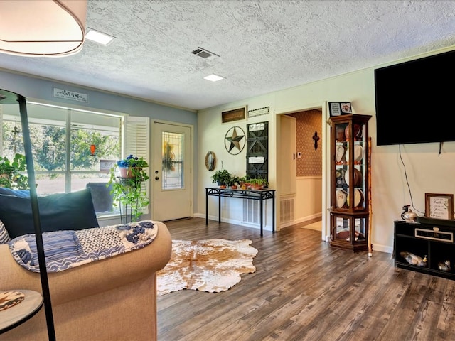 living room featuring dark hardwood / wood-style flooring and a textured ceiling