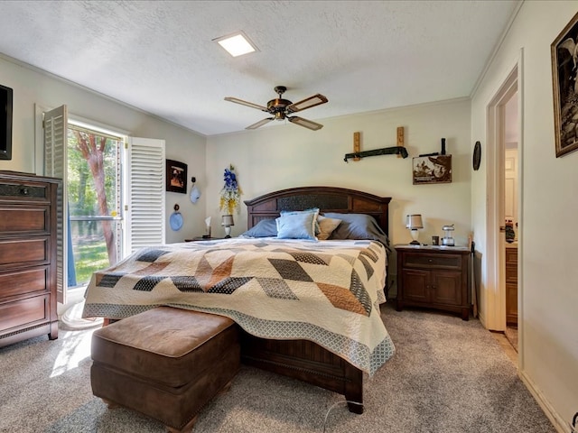 carpeted bedroom featuring ceiling fan and a textured ceiling