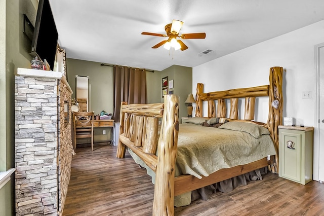 bedroom with a ceiling fan, visible vents, and wood finished floors