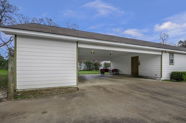 garage featuring an attached carport and driveway