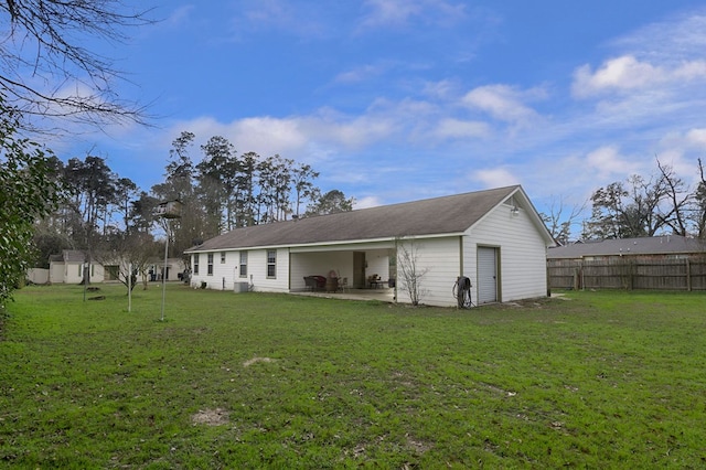 back of house featuring a patio, a lawn, and fence