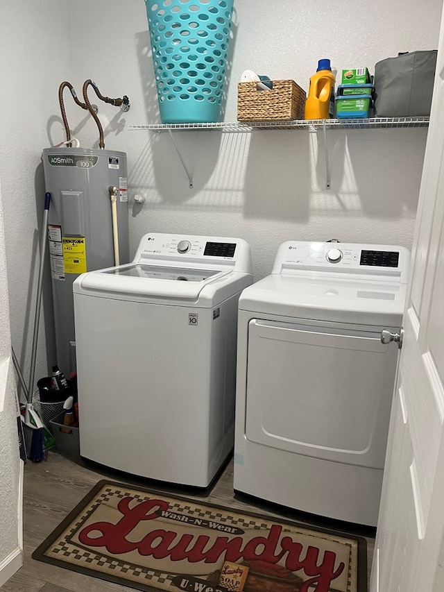 washroom featuring water heater, wood-type flooring, and independent washer and dryer