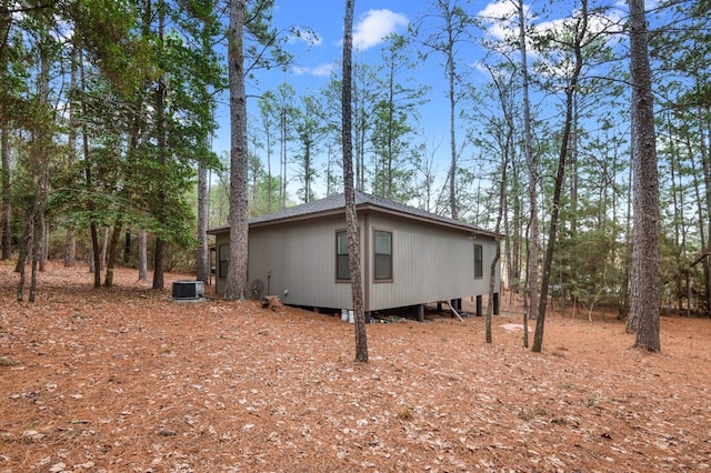 view of property exterior with a shingled roof and cooling unit