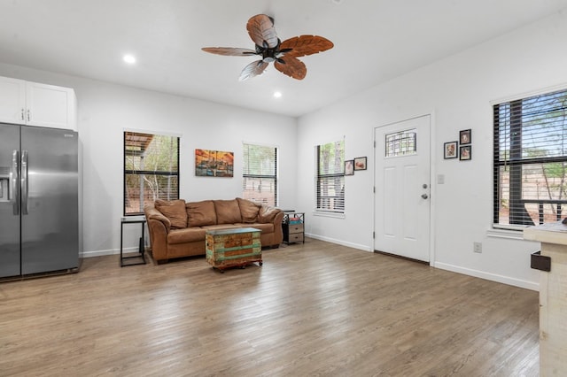 living area featuring ceiling fan, recessed lighting, light wood-type flooring, and baseboards