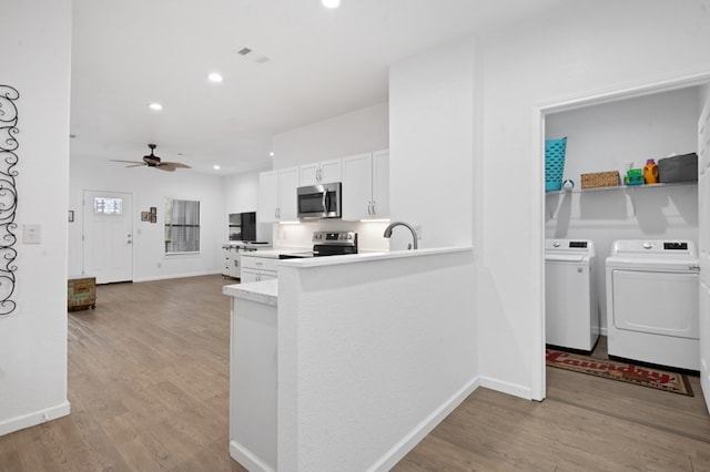 kitchen with light wood-style floors, visible vents, stainless steel appliances, and washer and dryer