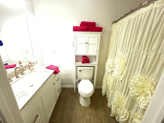 bathroom featuring wood-type flooring, toilet, and vanity