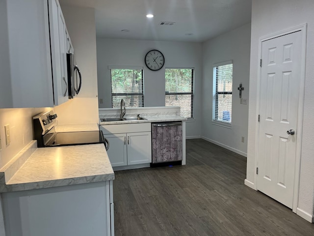 kitchen with appliances with stainless steel finishes, sink, dark wood-type flooring, and white cabinets