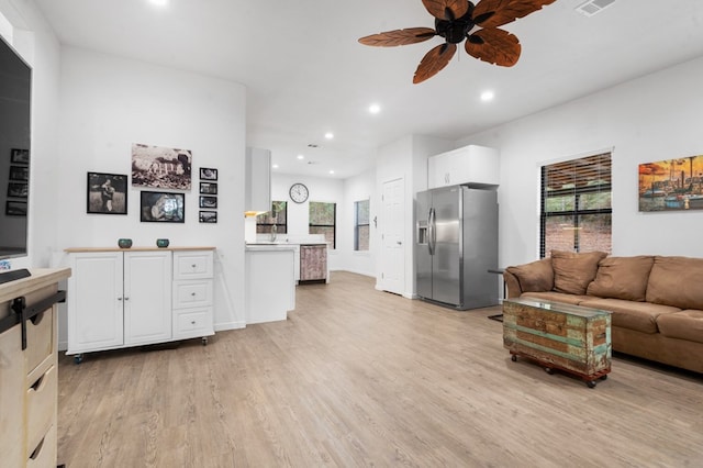 living area featuring light wood-style floors, a ceiling fan, and recessed lighting