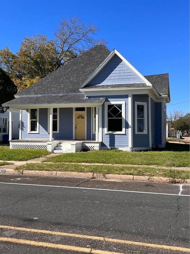 bungalow-style house with a shingled roof, a porch, and a front yard