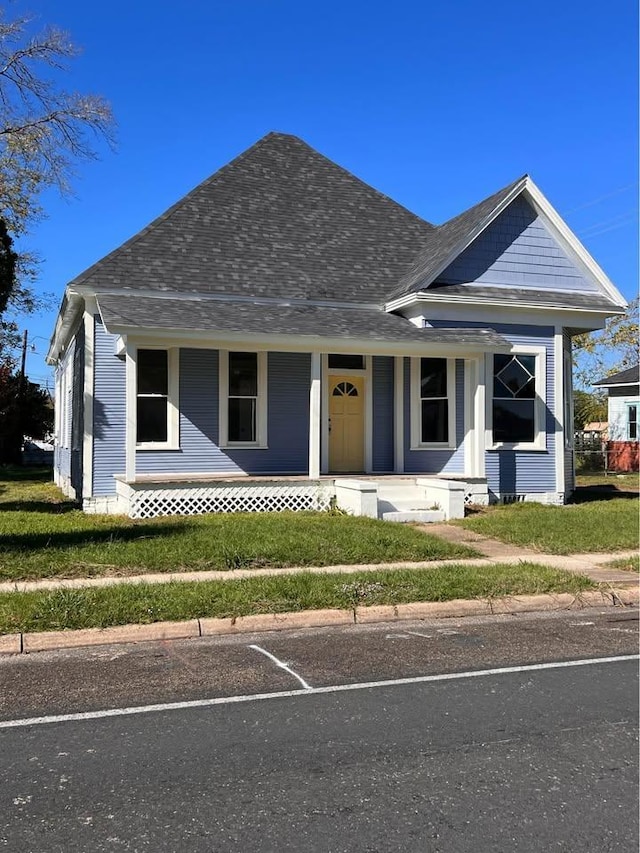 bungalow with covered porch and roof with shingles