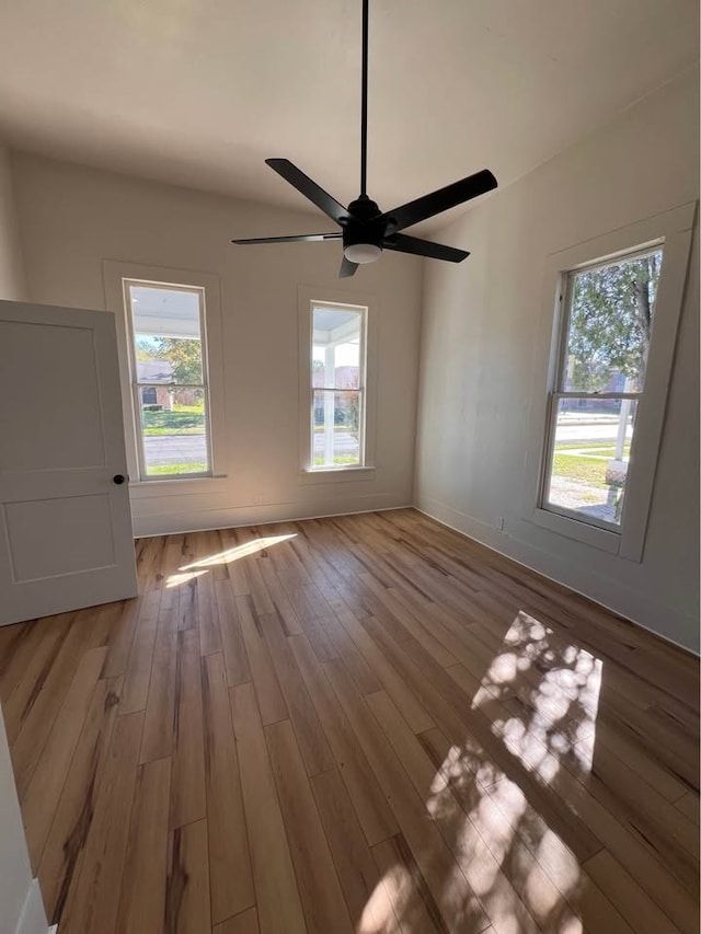 unfurnished room with a wealth of natural light and wood finished floors