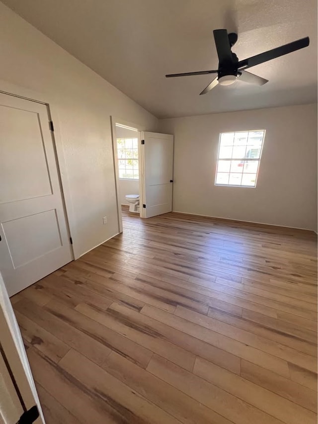 empty room featuring lofted ceiling, ceiling fan, and wood finished floors