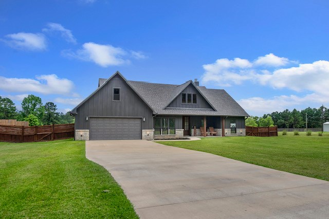 685 Box Car Rd, Lufkin, TX 75904 - view of front of home featuring driveway, a chimney, board and batten siding, and an attached garage