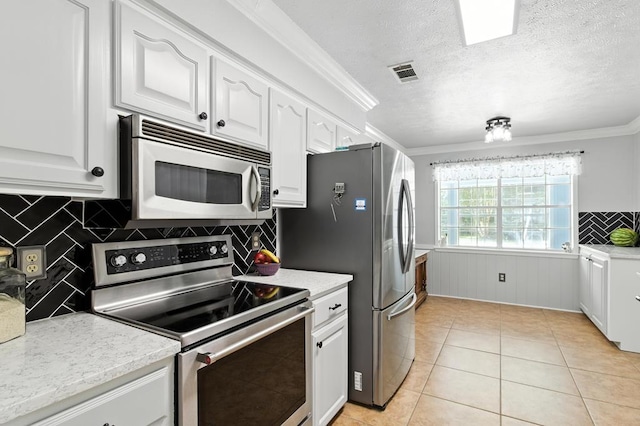 3198 Old Union Rd, Lufkin, TX 75904 - kitchen featuring appliances with stainless steel finishes, white cabinets, ornamental molding, tasteful backsplash, and light countertops