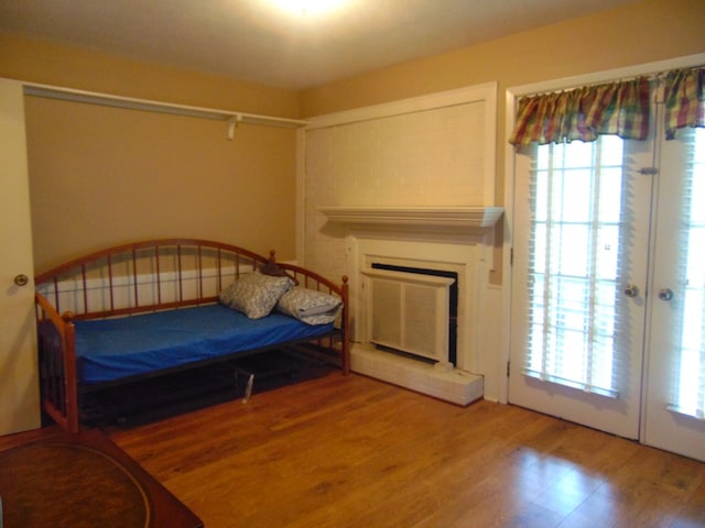 3198 Old Union Rd, Lufkin, TX 75904 - bedroom featuring wood finished floors, a fireplace with raised hearth, and multiple windows