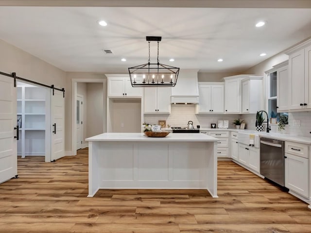 282 Lancewood Dr, Lufkin, TX 75904 - kitchen featuring a barn door, tasteful backsplash, a sink, dishwasher, and light wood-style flooring