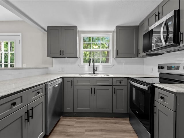 3202 Chimney Rock Ln, Nacogdoches, TX 75965 - kitchen with appliances with stainless steel finishes, gray cabinetry, plenty of natural light, and tasteful backsplash