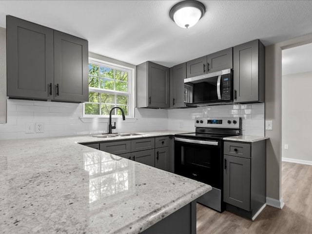 3202 Chimney Rock Ln, Nacogdoches, TX 75965 - kitchen featuring stainless steel electric stove, gray cabinetry, backsplash, and light stone countertops