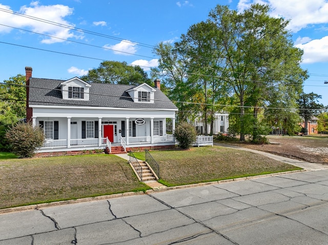 cape cod-style house featuring covered porch and a front lawn