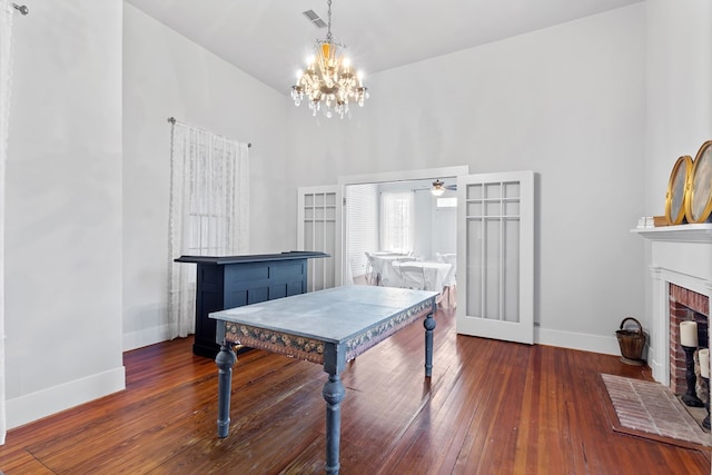 playroom featuring a fireplace, dark hardwood / wood-style flooring, and ceiling fan with notable chandelier