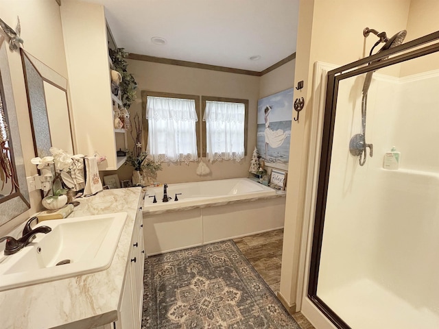 bathroom featuring vanity, separate shower and tub, and ornamental molding