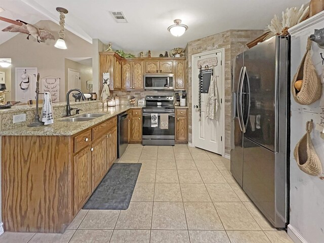 kitchen with sink, decorative light fixtures, light tile patterned floors, appliances with stainless steel finishes, and kitchen peninsula
