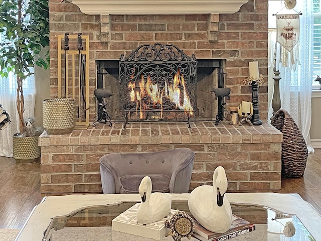 interior details with a brick fireplace and wood-type flooring