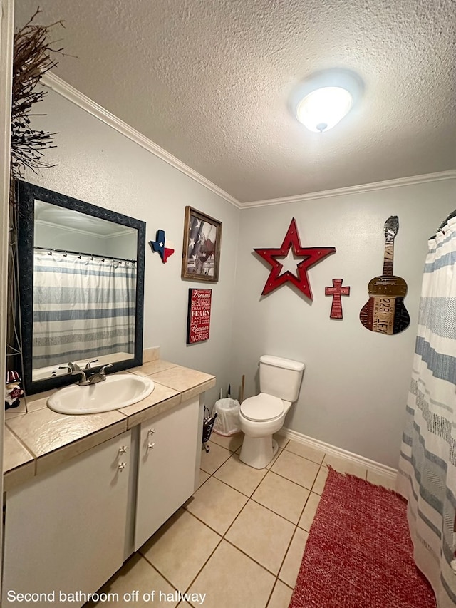 785 County Road 105, San Augustine, TX 75972 - bathroom featuring a textured ceiling, tile patterned flooring, vanity, toilet, and ornamental molding