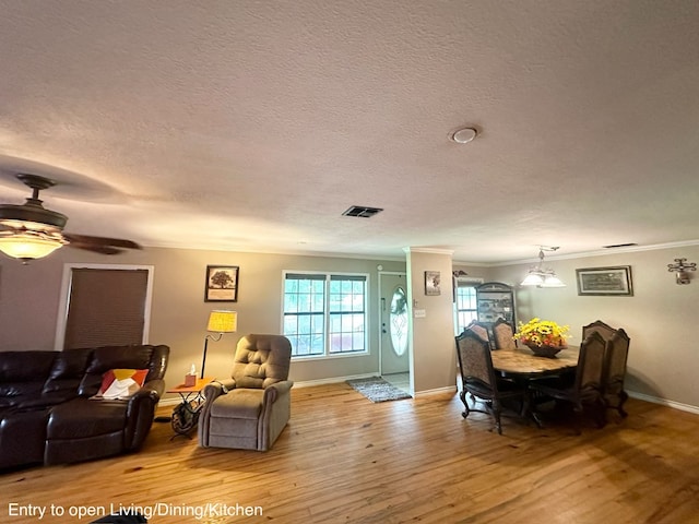 785 County Road 105, San Augustine, TX 75972 - living area featuring a textured ceiling, visible vents, crown molding, wood finished floors, and baseboards