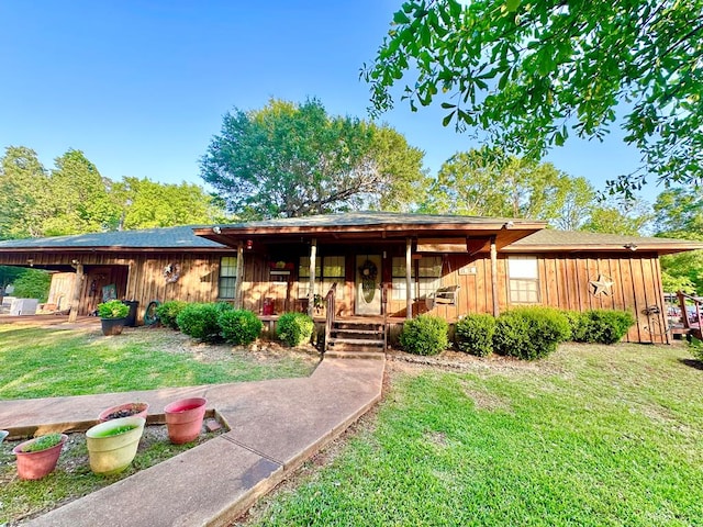 785 County Road 105, San Augustine, TX 75972 - view of front of home with covered porch, board and batten siding, and a front yard