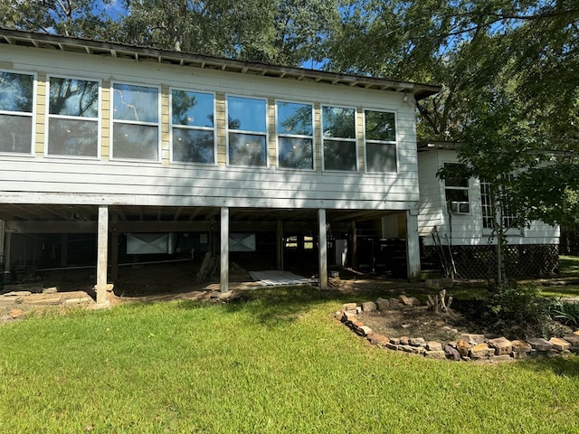 rear view of property with a carport, a yard, and driveway