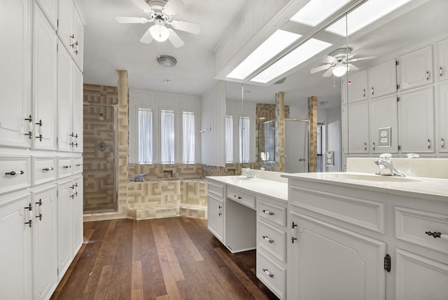 bathroom with vanity, ceiling fan, wood-type flooring, and a shower with door