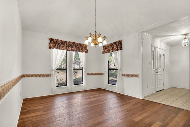 unfurnished dining area featuring a notable chandelier, wood-type flooring, and crown molding