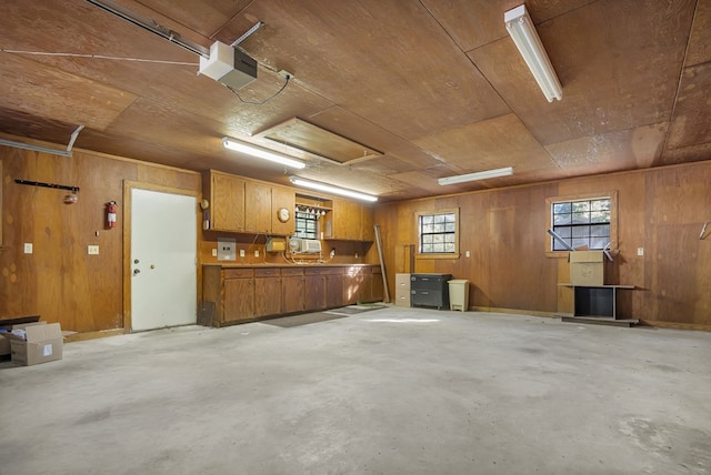 garage featuring wooden walls, wooden ceiling, and a garage door opener