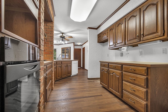 kitchen with ceiling fan, sink, dark hardwood / wood-style floors, kitchen peninsula, and ornamental molding