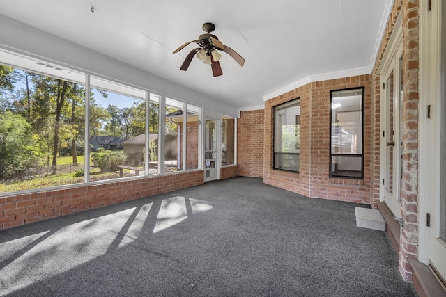 unfurnished sunroom with ceiling fan