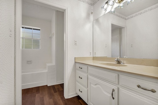 bathroom with vanity, wood-type flooring, and shower / washtub combination