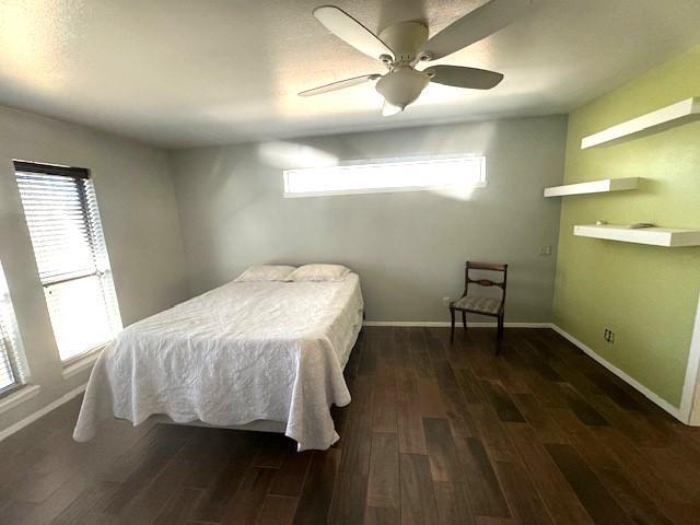 bedroom with ceiling fan and dark wood-type flooring